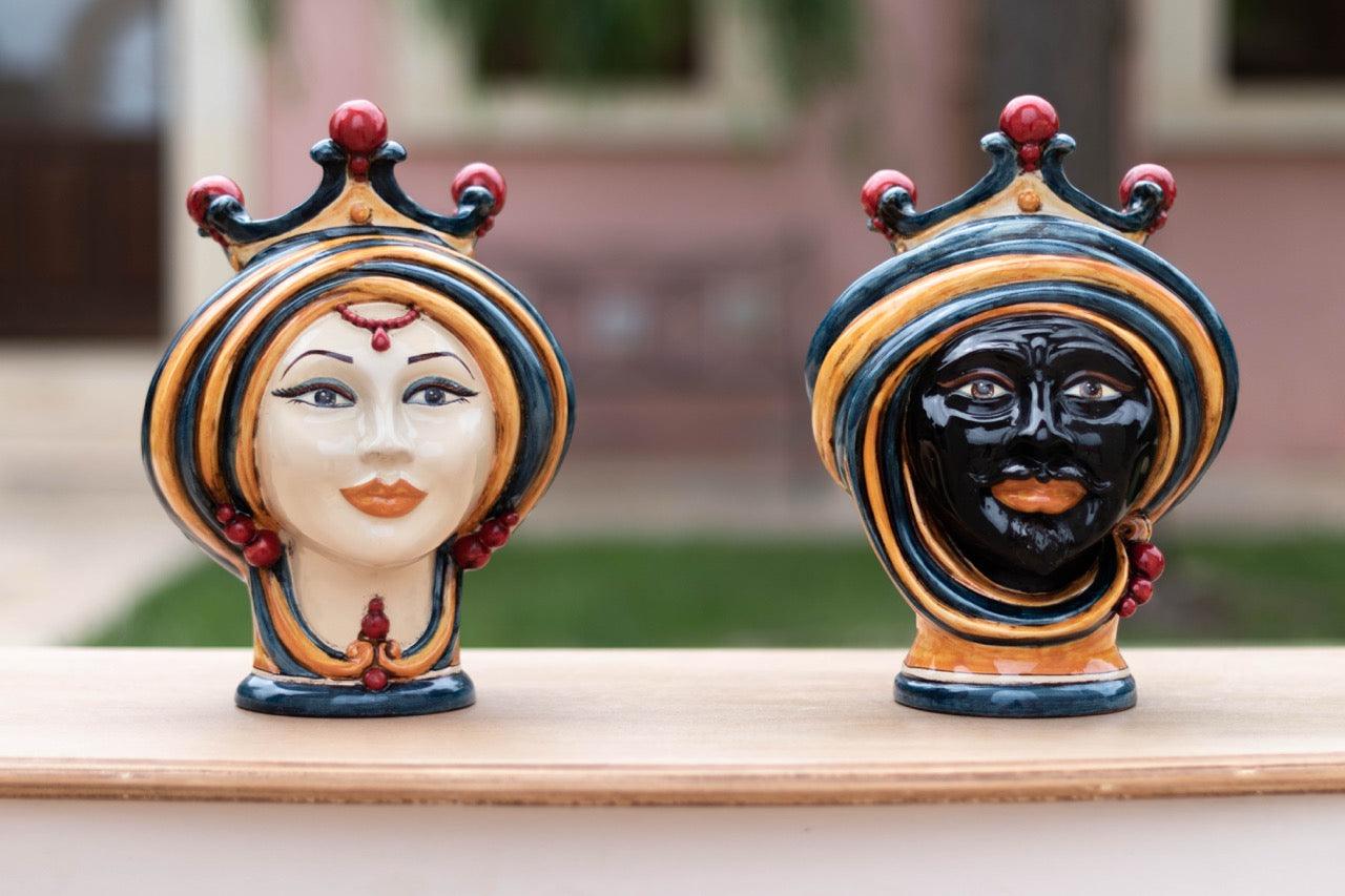 Ceramic Teste di Moro head vases with blue, orange and red crowns, outdoor setting