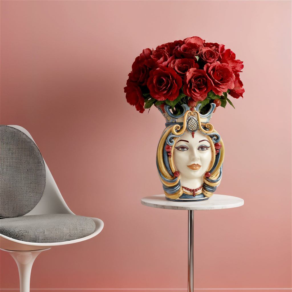 Handcrafted Teste di Moro vase with red roses, blending Sicilian tradition and modern decor on a marble table.