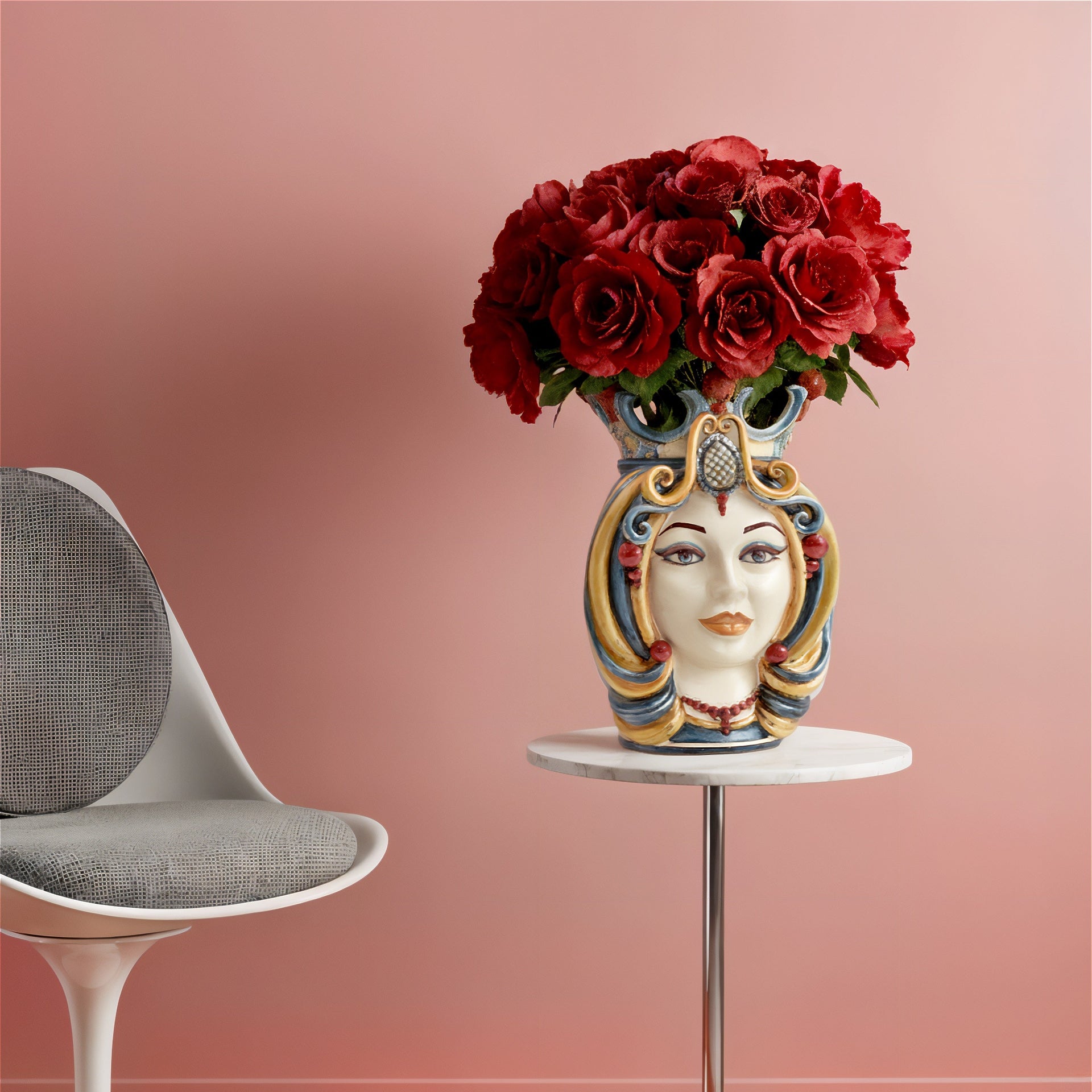 Handcrafted Teste di Moro vase with red roses, blending Sicilian tradition and modern decor on a marble table.