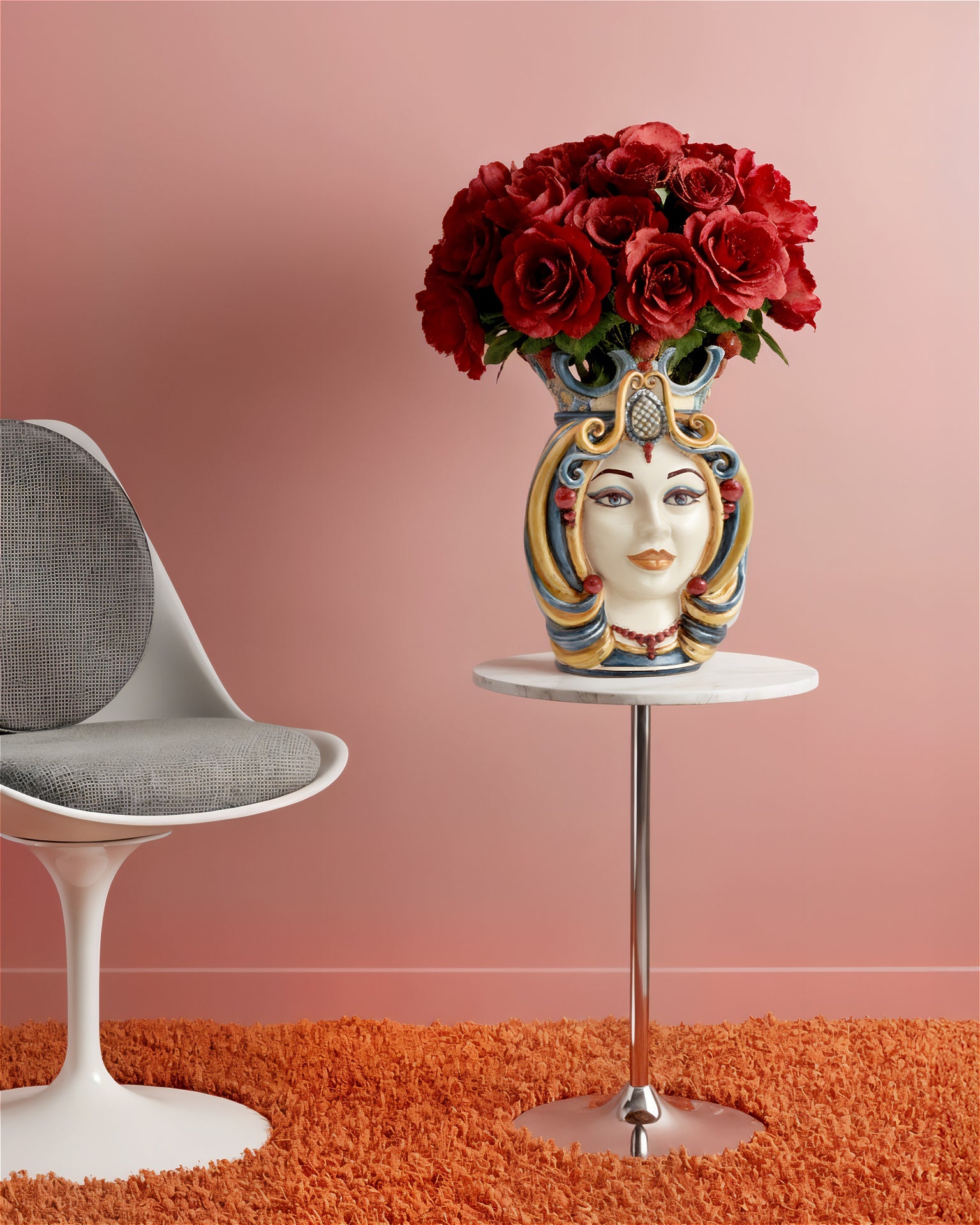Handcrafted Teste di Moro vase with red roses, blending Sicilian tradition and modern decor on a marble table.