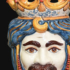 Handcrafted Teste di Moro ceramic face with vibrant blue hair and ornate crown, blending tradition and modern design.