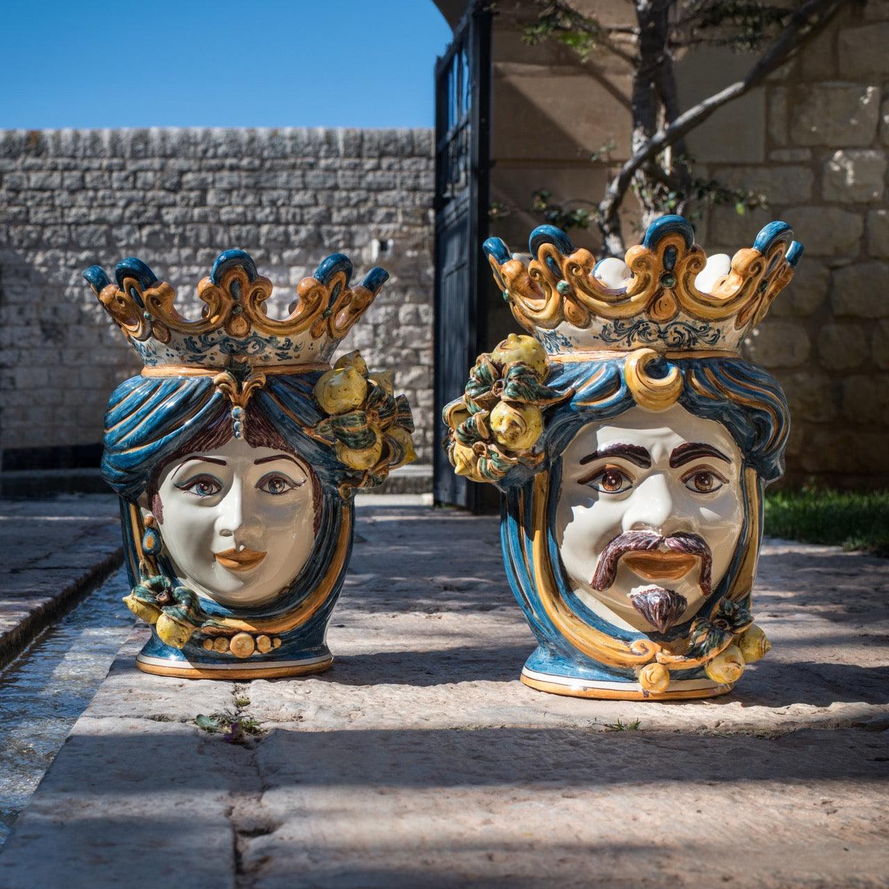 Handmade Teste di Moro ceramic vases with crowns, blue and gold details, set outdoors on stone