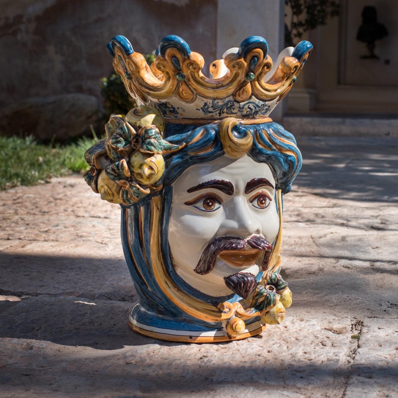 Handcrafted Teste di Moro ceramic vase with crown, vibrant blue and gold details, outdoor display