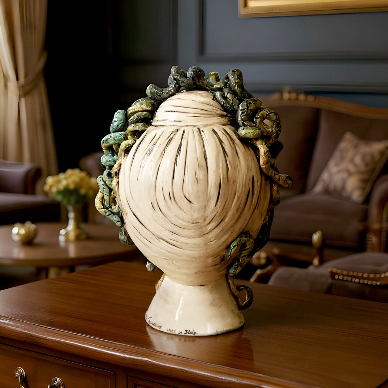 Handcrafted Sicilian ceramic Medusa head vase with detailed snakes, displayed on a wooden table