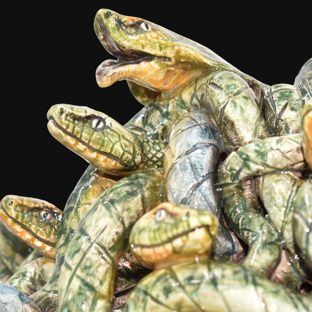 Handcrafted ceramic snakes with green glaze, intricate details, and expressive eyes, perfect for modern or traditional decor.