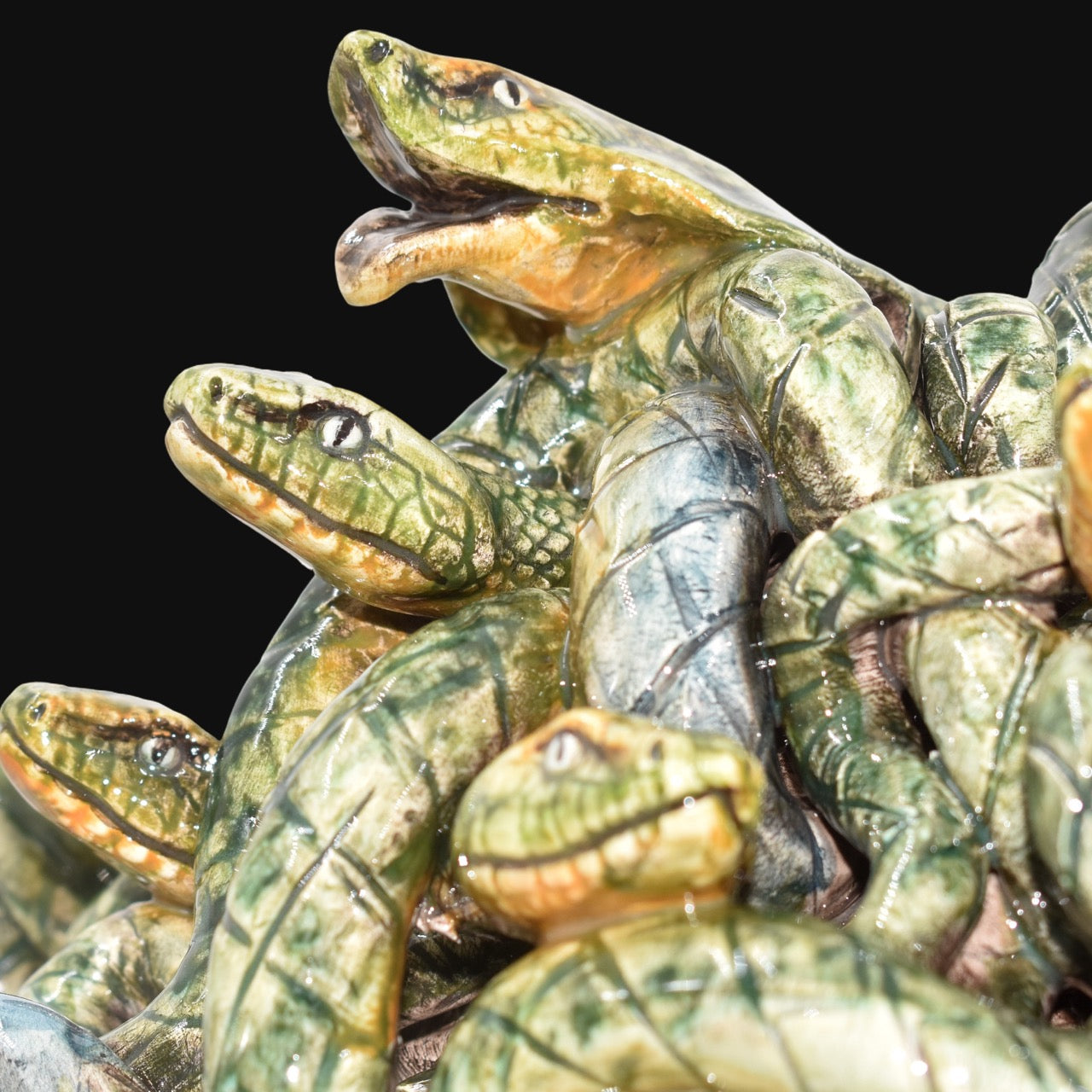 Handcrafted ceramic snakes with green glaze, intricate details, and expressive eyes, perfect for modern or traditional decor.